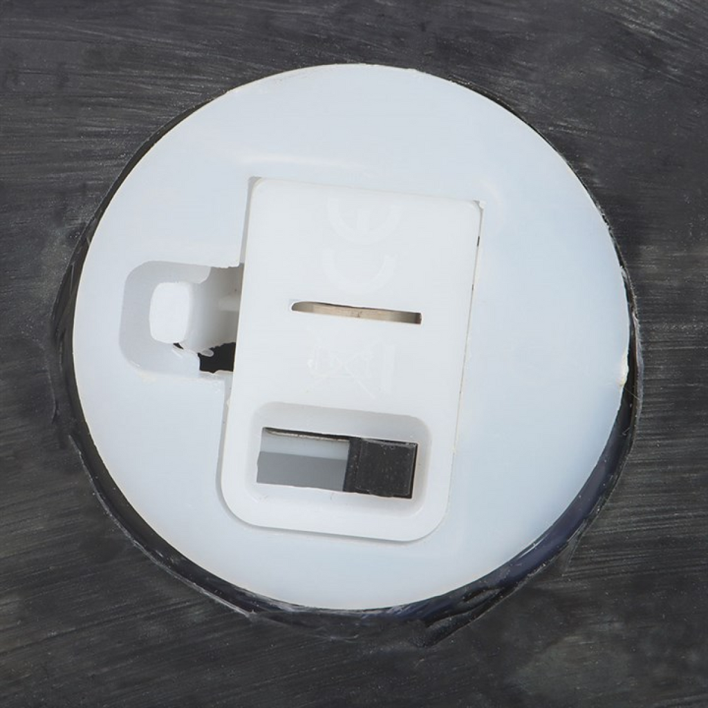 Close-up of a white electrical plug on a dark surface