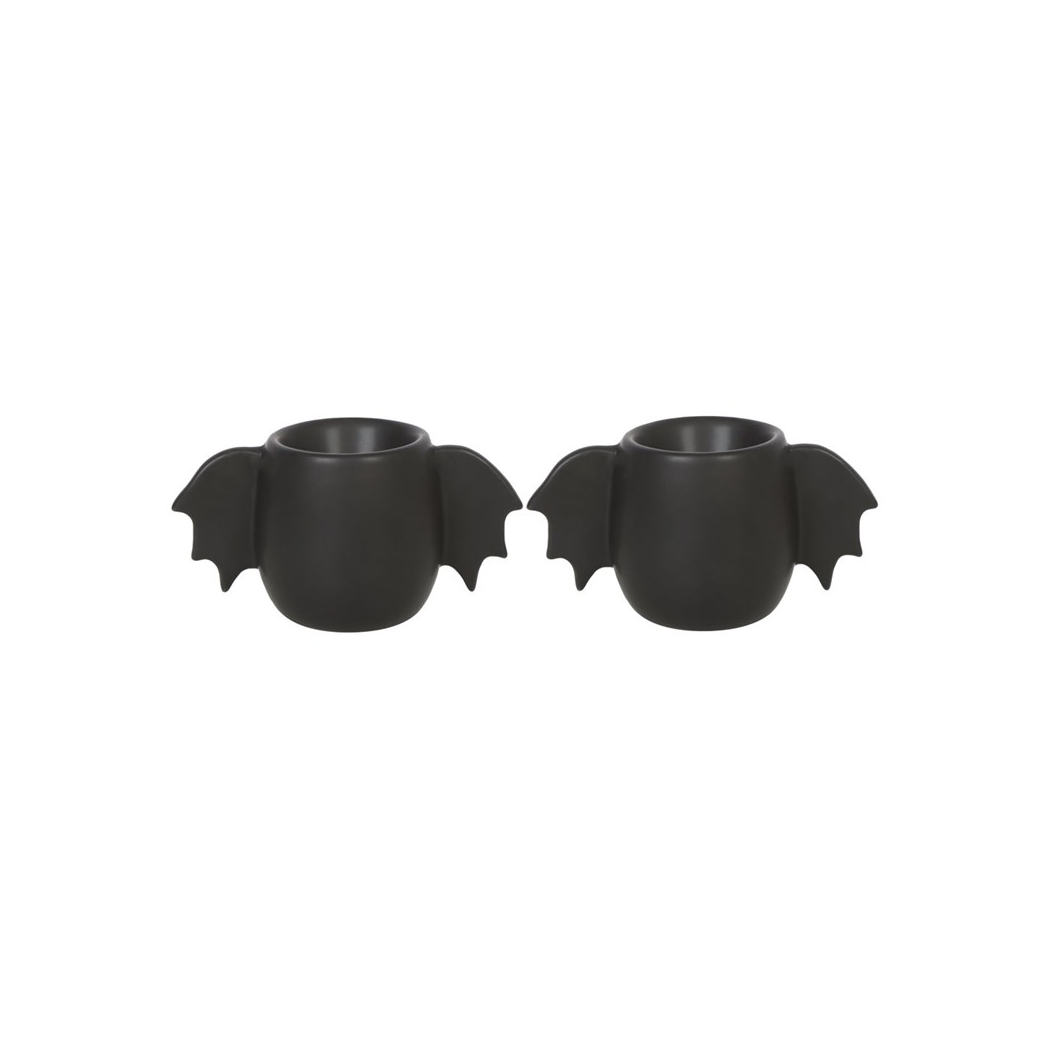 Two black bat-shaped candle holders on a white background