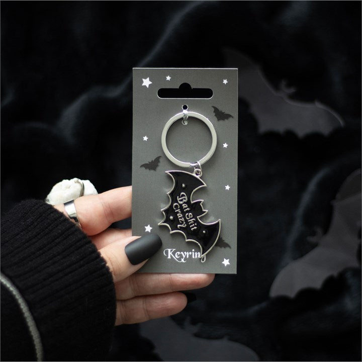 Keychain with bat design held by a hand against a dark background
