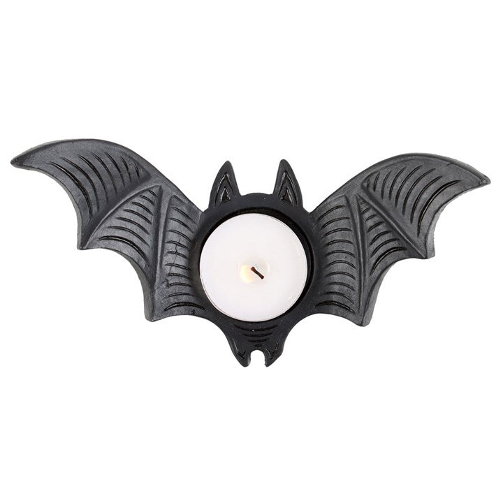Bat-shaped candle holder with a lit candle on a white background
