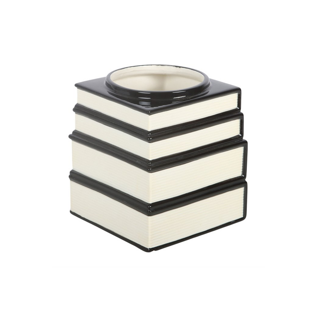 Stack of black and white books with a round object on top against a white background
