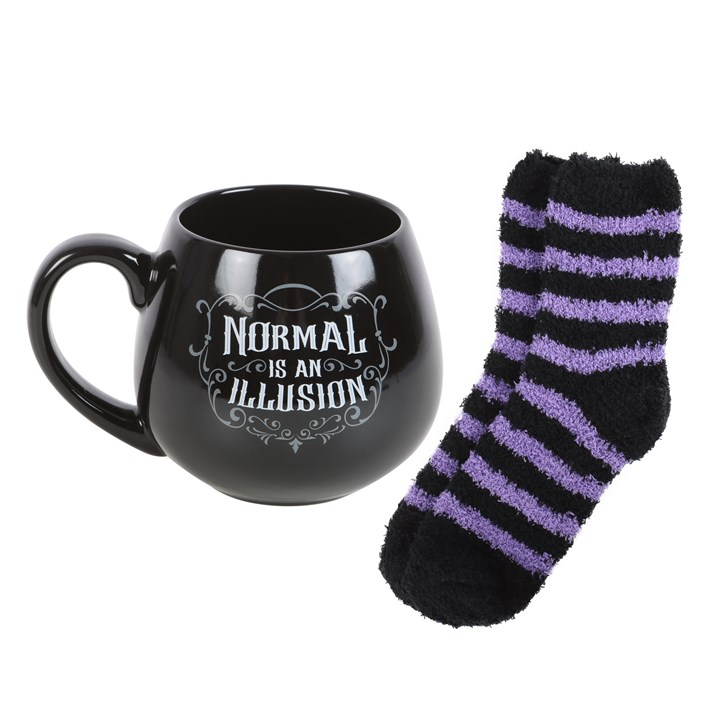Black mug with 'Normal is an Illusion' text and black and purple striped socks on a white background