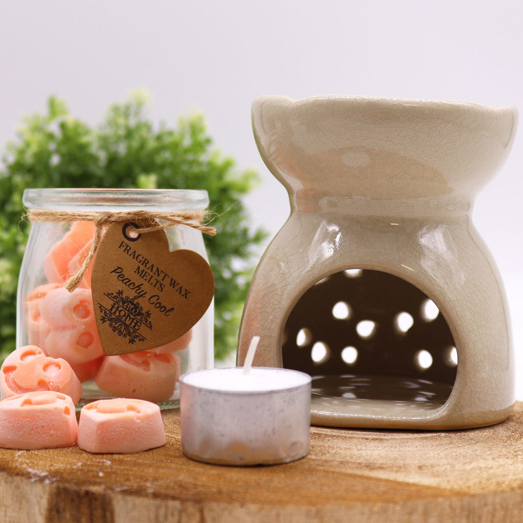 Ceramic wax warmer with jar of wax melts and tealight on wooden surface