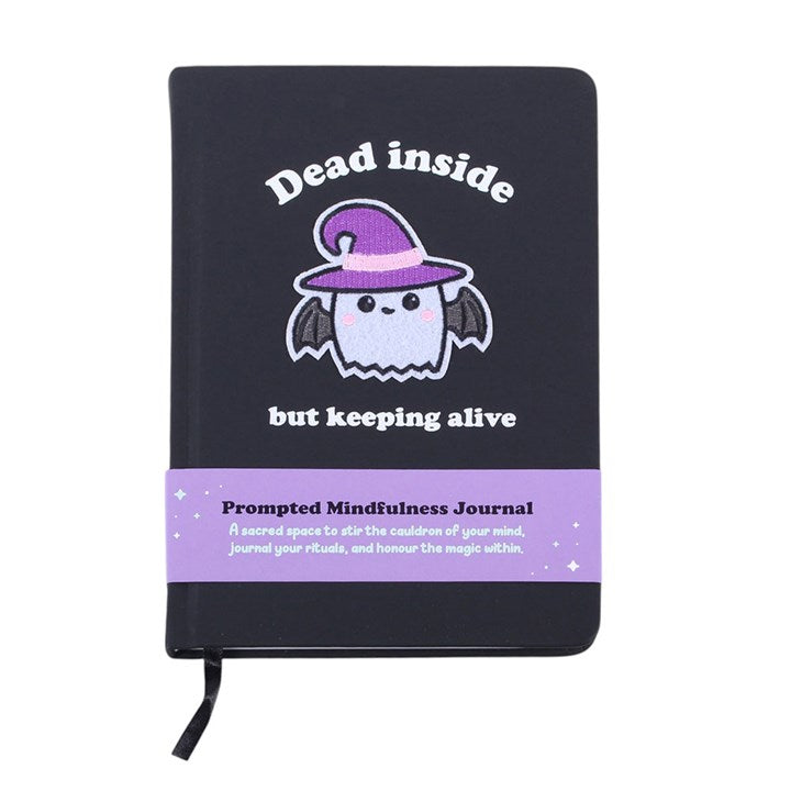 Black journal with a cartoon bat wearing a witch hat and text on a white background