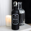 Black bottle labeled 'Deadly Poison' with a candle in the background
