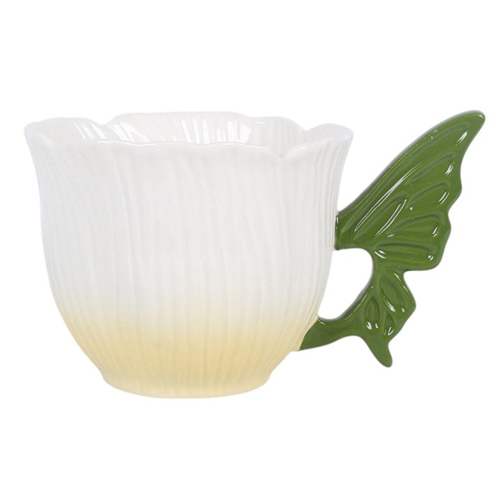 A ceramic cup with a white to pale yellow gradient body, featuring a fluted texture and a sculpted green wing-shaped handle, shown on a plain white background.