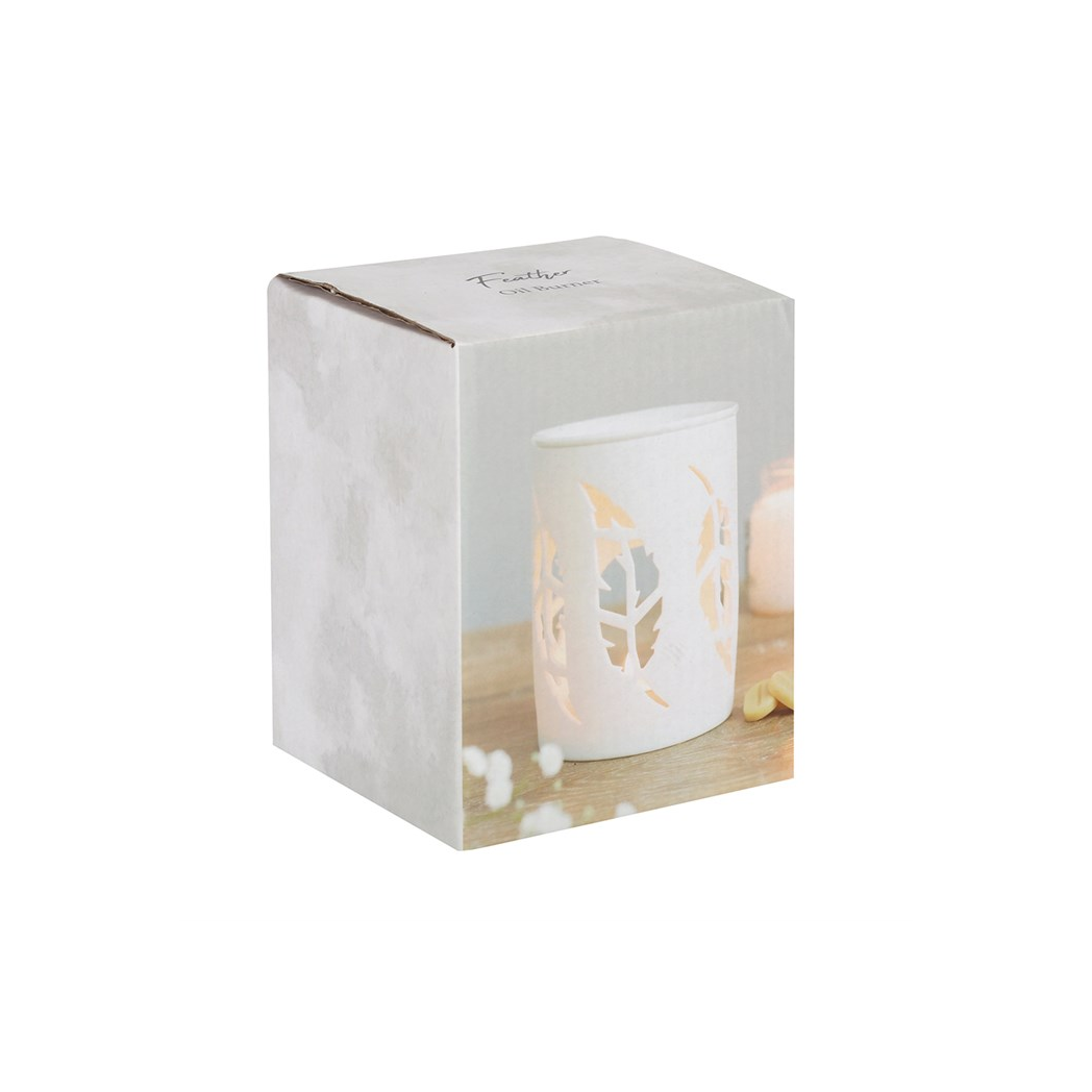 White candle in a decorative holder inside a branded box on a white background