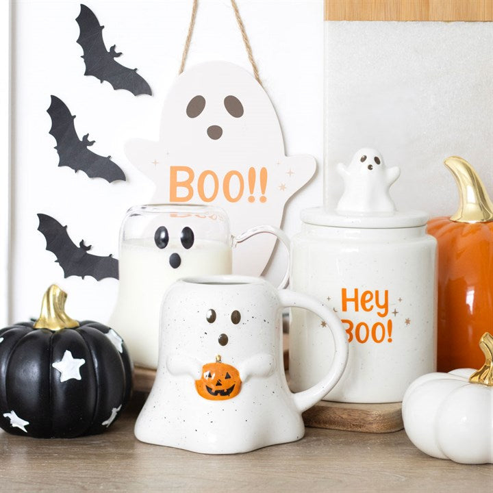 Halloween-themed mugs with ghost designs and text, surrounded by pumpkins and bats.