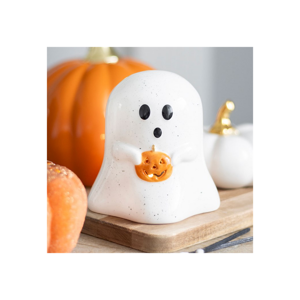 Halloween-themed ceramic ghost with pumpkin on a wooden board, surrounded by pumpkins.