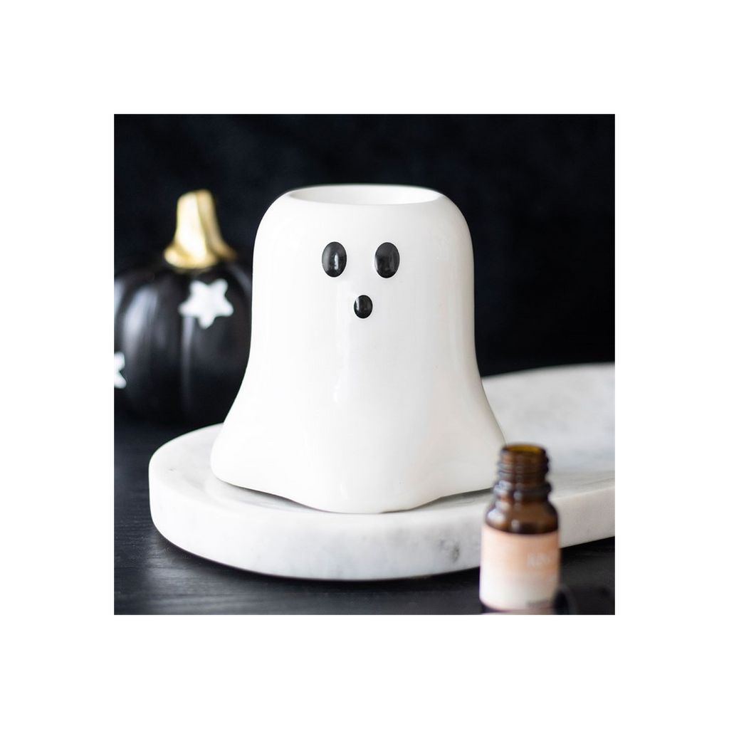 Ghost-shaped diffuser on a marble surface with pumpkins in the background