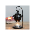 Black metal candle holder with a small candle on a wooden surface.