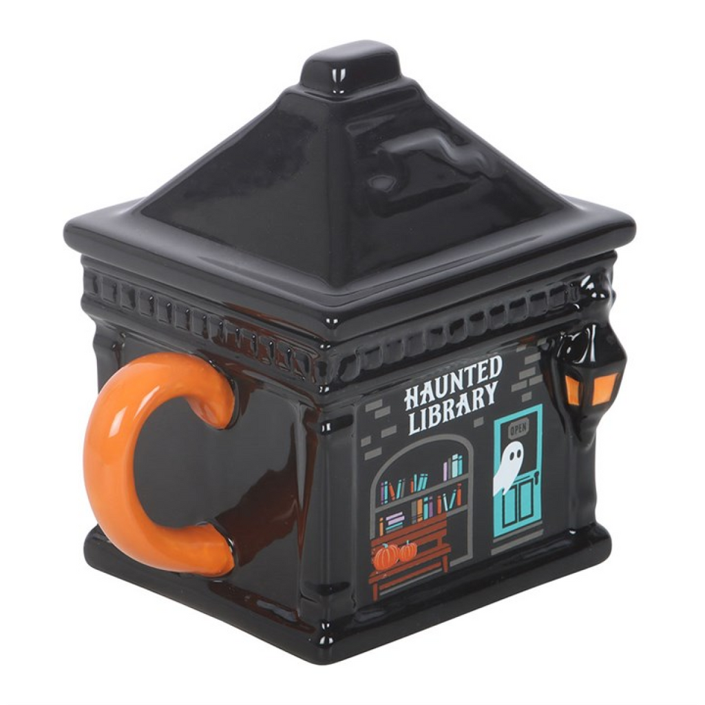 Halloween-themed mug shaped like a haunted library with an orange handle on a white background