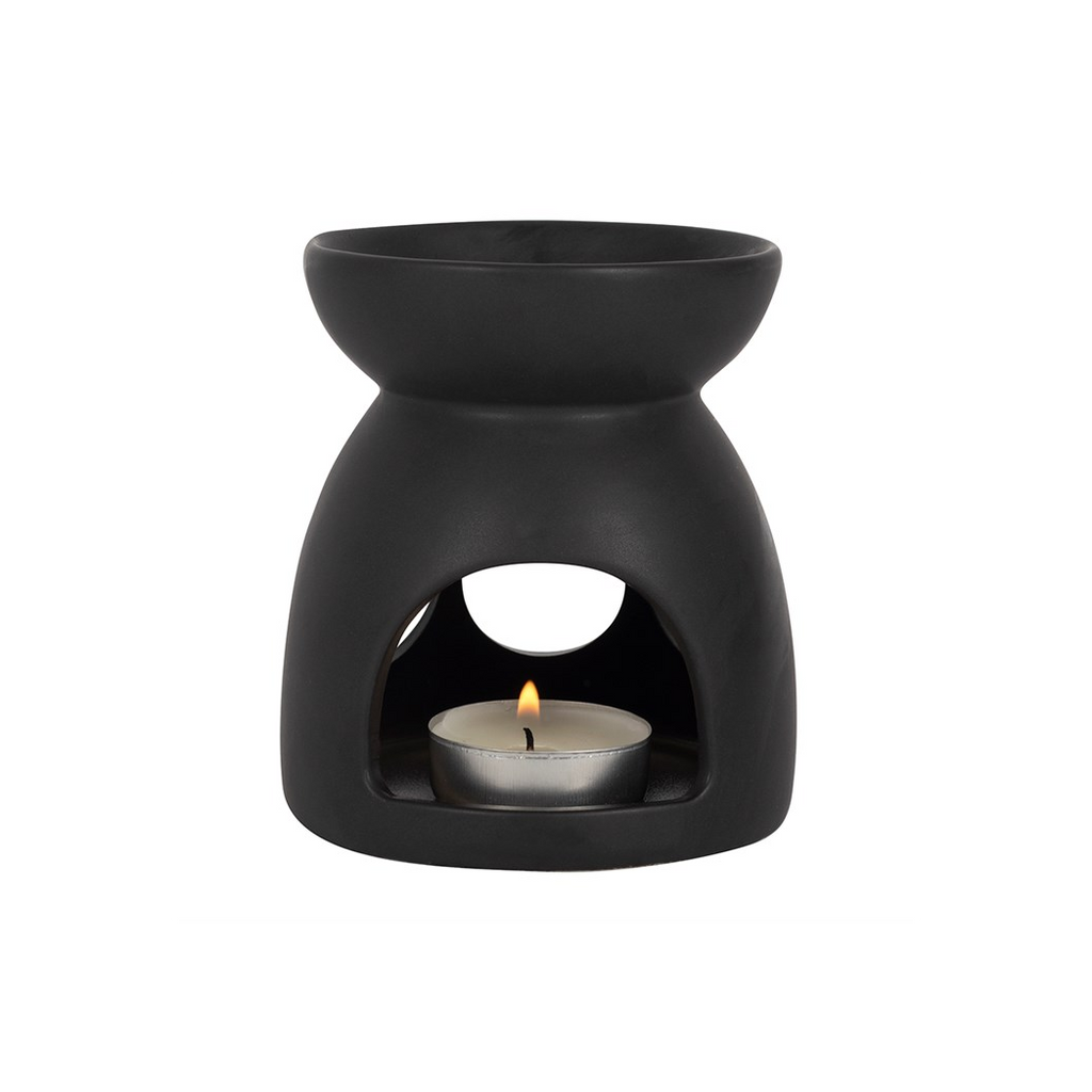 Black ceramic oil burner with a lit candle inside on a white background