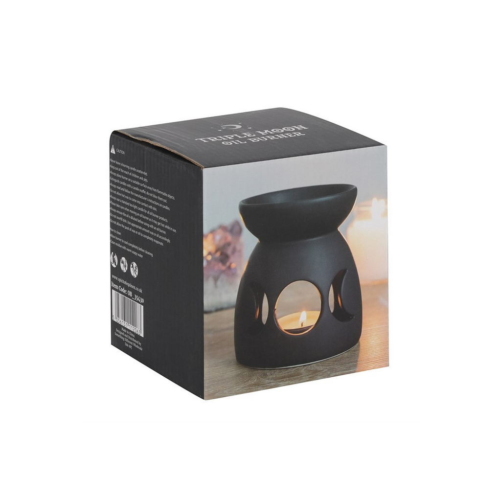 Black ceramic oil burner on a product packaging box with a blurred background