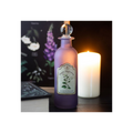 Purple potion bottle labeled 'Magical Potion' next to a lit candle on a dark background