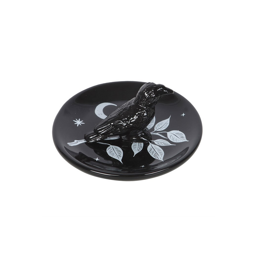 Black decorative plate with white designs on a white background