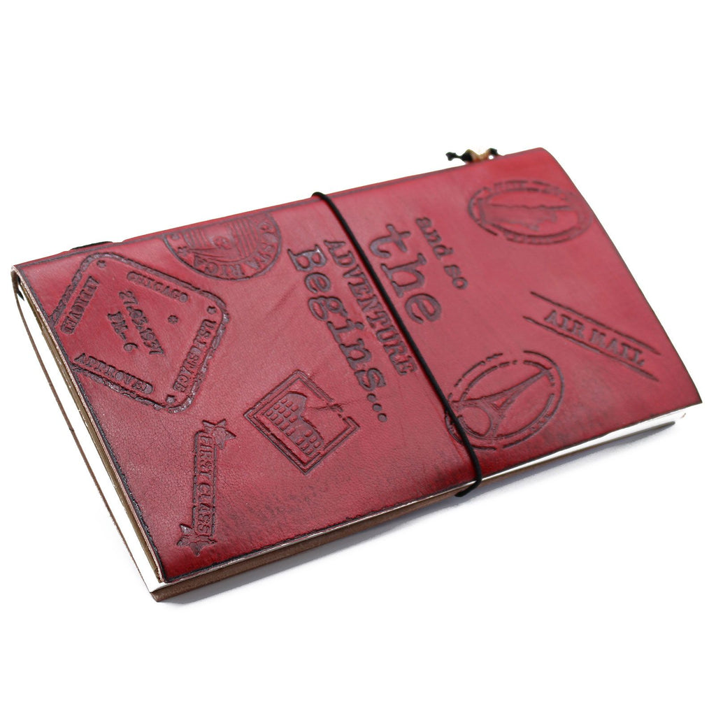 Red leather notebook with embossed designs on a white background