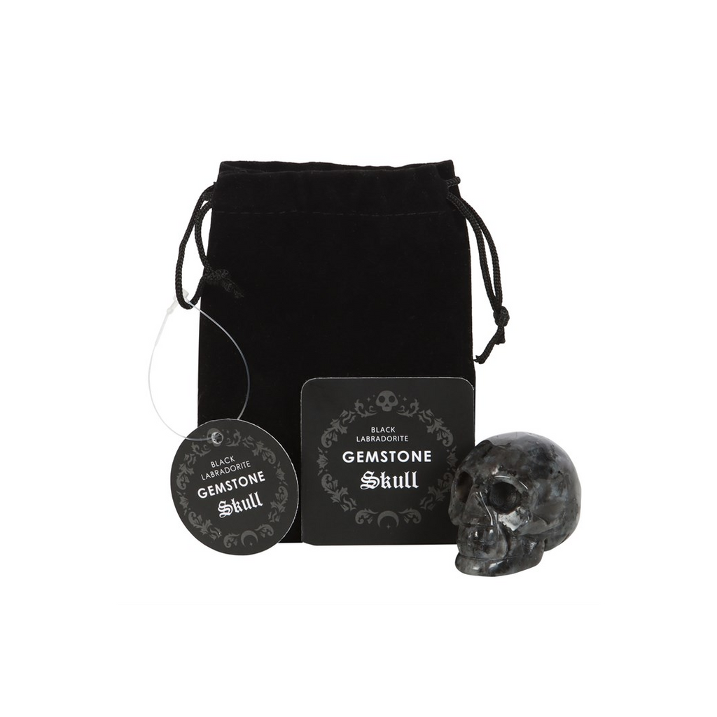 Black gemstone skull with packaging and card on a white background