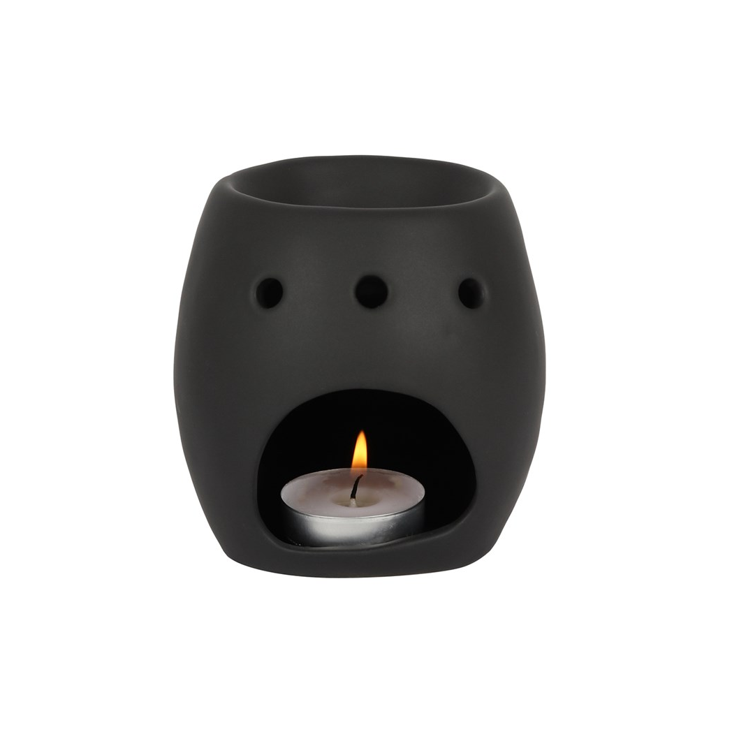 Black ceramic oil burner with a lit candle inside on a white background