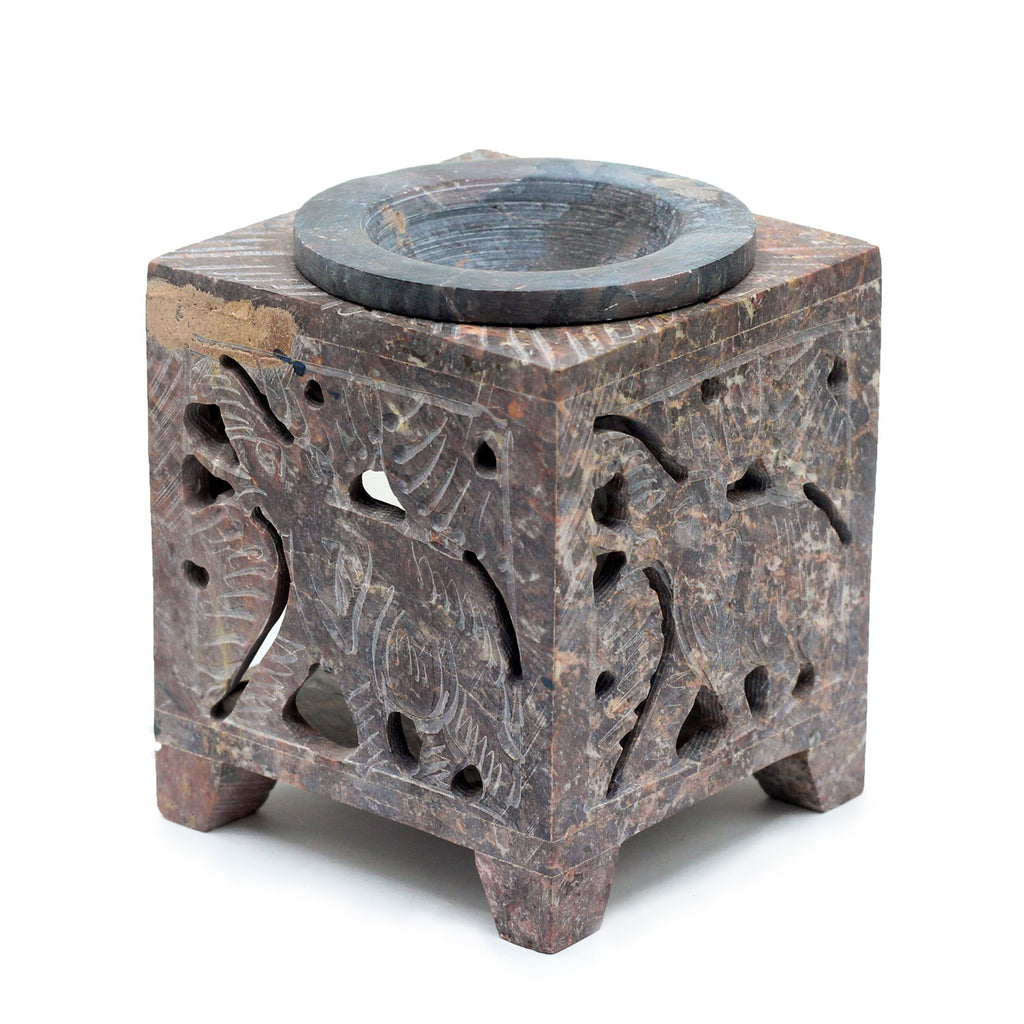 Square stone wax melter with cut-out designs on a white background