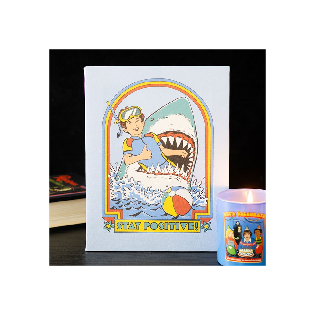 Illustrated card with a person holding a shark and 'Stay Positive!' text, next to a small cup with cartoon characters.