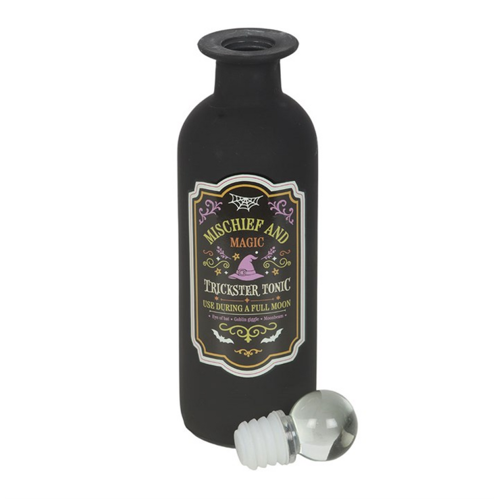 Black bottle with decorative label and clear bottle stopper on a white background