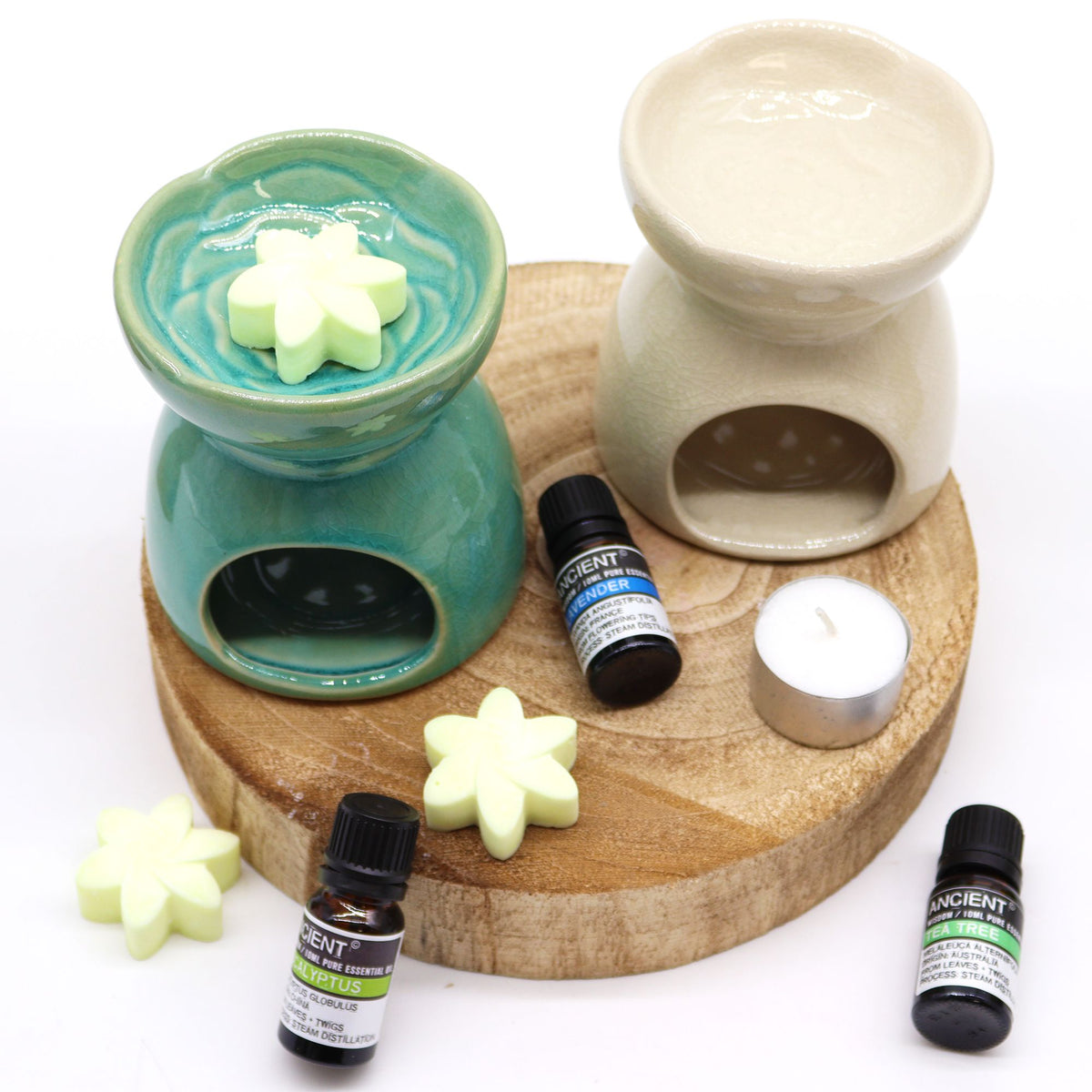 Aromatherapy diffuser set with essential oils and wax melts on a wooden board.